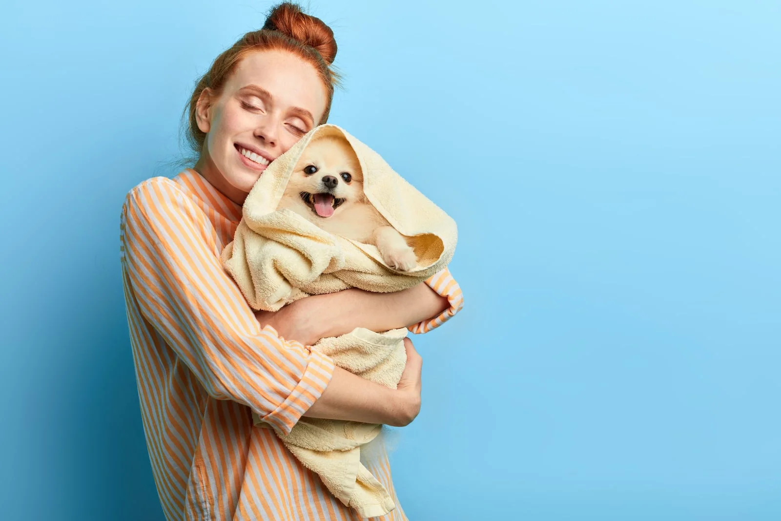 woman hugging dog with towel